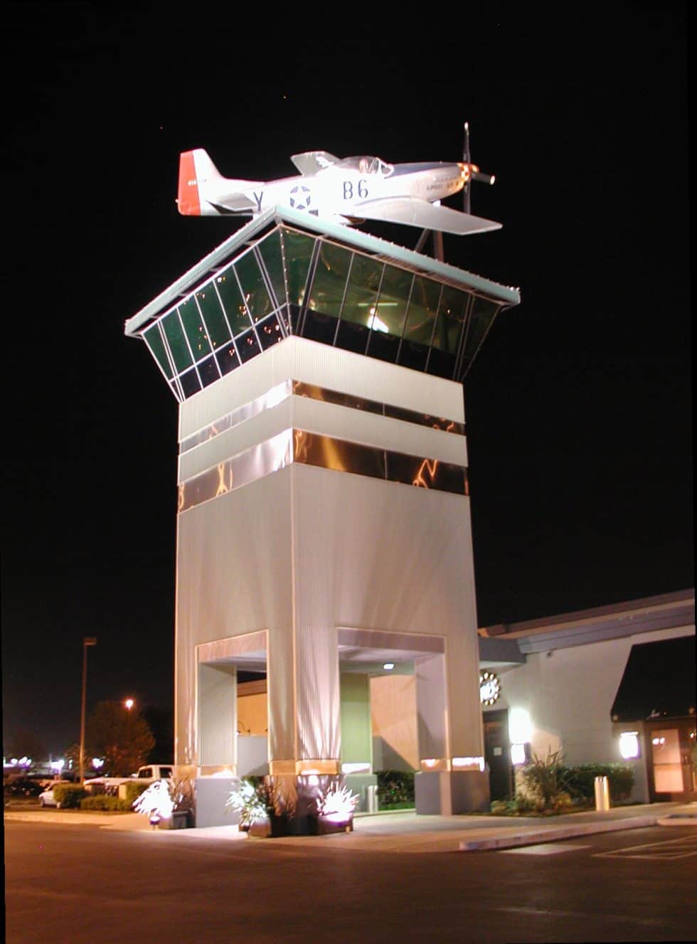 Aircraft model on top of a modern building nighttime photo, showcasing innovative architectural design.
